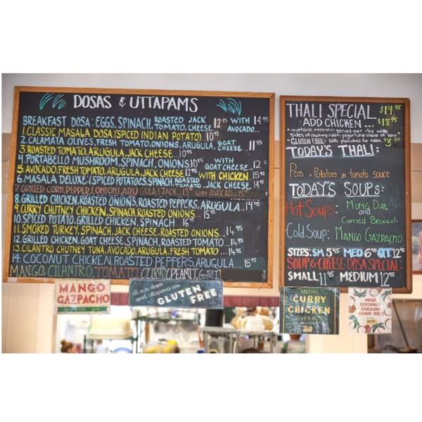 Chalkboard menus at Hampton Chutney Co. display Indian dosas, thali specials, and soups.