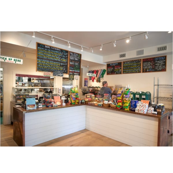 Interior of Hampton Chutney Co. with a counter, menus, and a person working behind the counter.